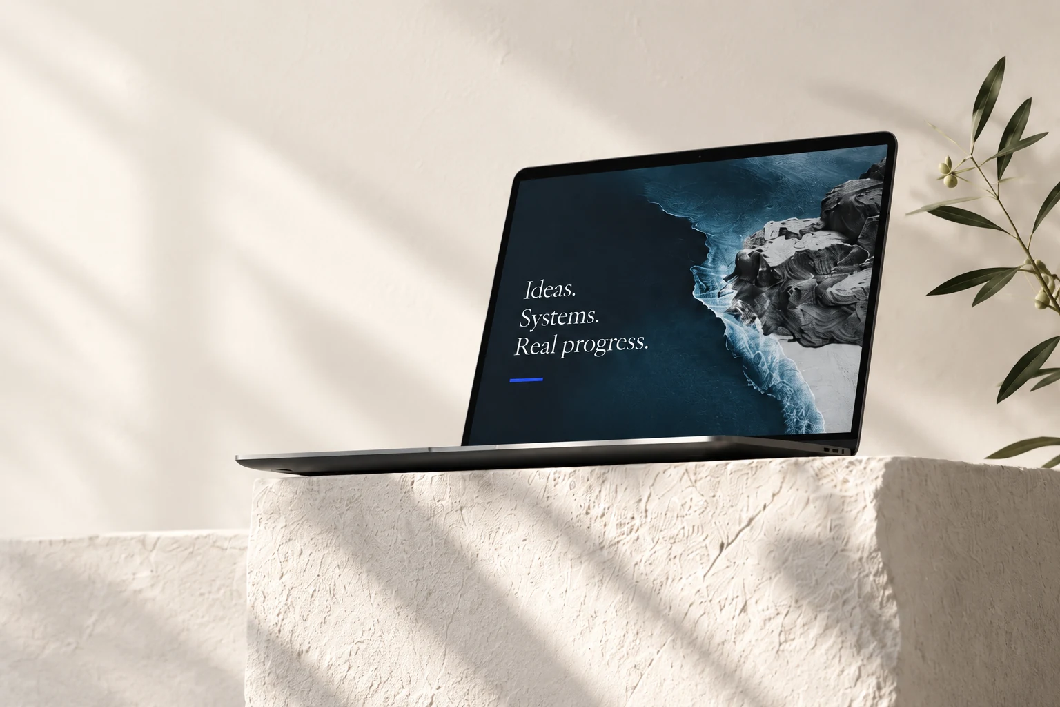 A laptop showing an ocean coastline on an ivory stone plinth